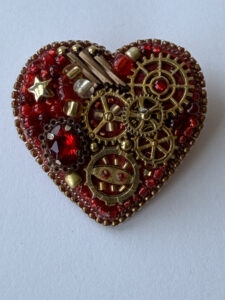 Red Steampunk Heart Brooch with Watch Movement Gears – Hand-Embroidered Faceted-Bead Pin — lifestyle photo